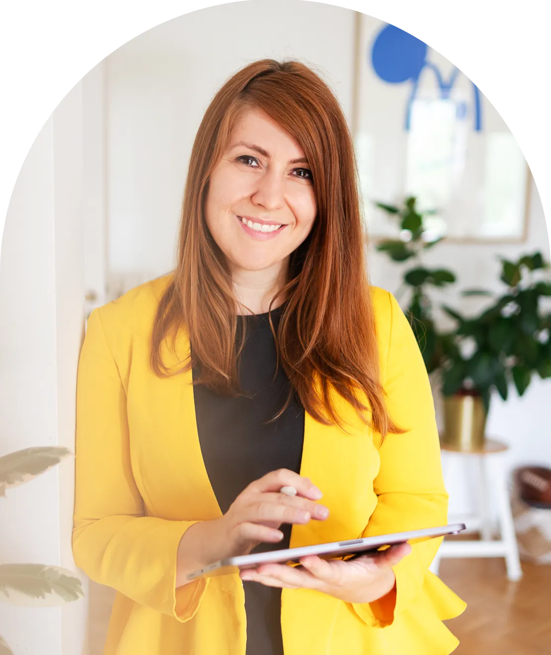 Kathrin Schönborn mit einem gelben Blazer und einem iPad in der Hand