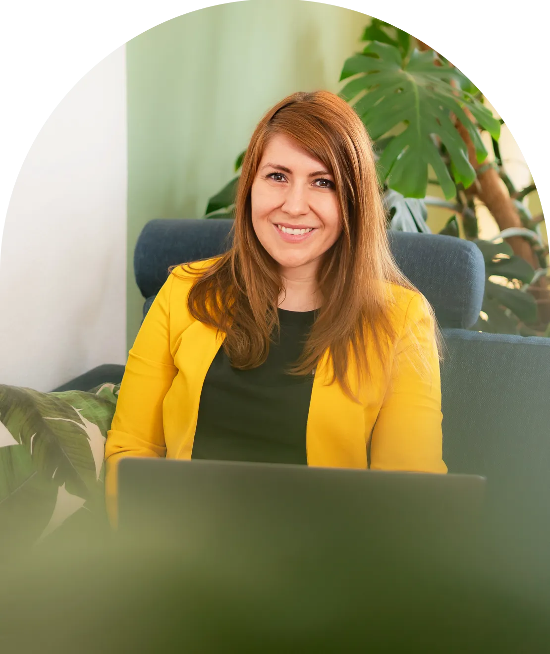 Kathrin Schönborn trägt einen gelben Blazer und sitzt auf einem Sofa